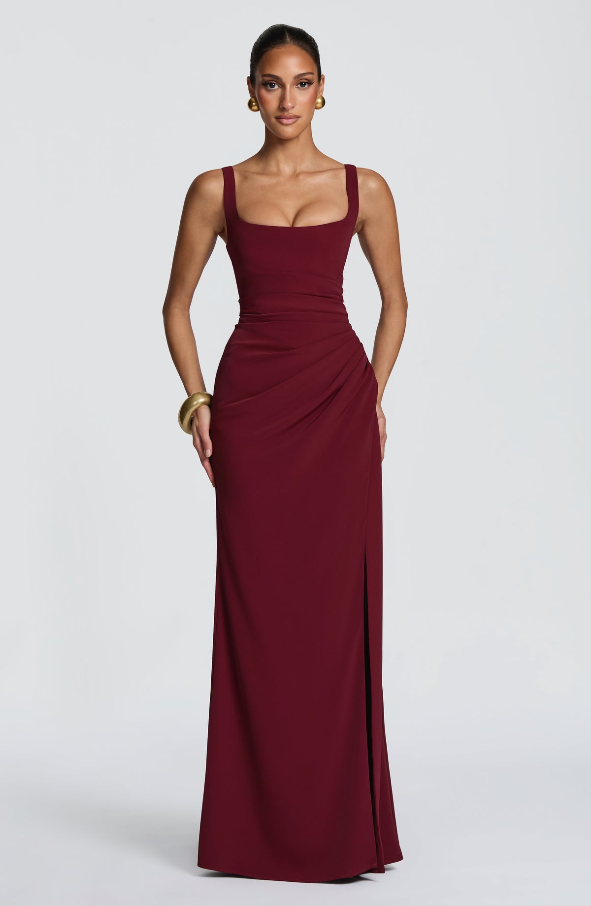 Front view of the burgundy maxi dress on a model, showing fitted bodice, ruched waist and side slit. 20