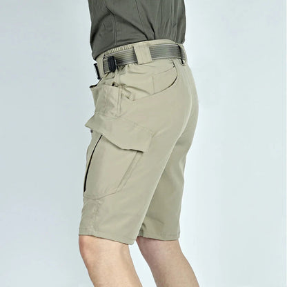 Man wearing khaki cargo shorts and a belt, seen from the side to show the large flapped thigh pocket and the fit. 5