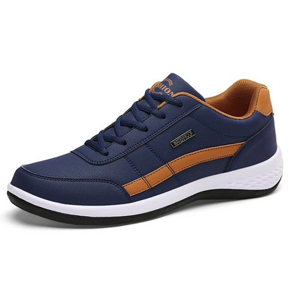 Navy blue lace-up sneaker with tan side stripe, tan collar and white midsole, shown on a plain white background. 5