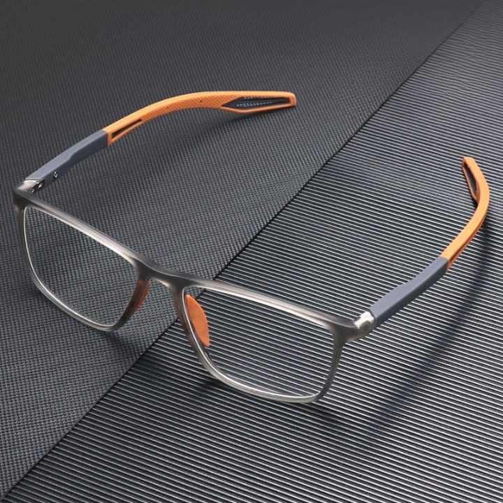 Translucent grey glasses with orange arm tips, shown from a high angle on a dark ridged surface. 4