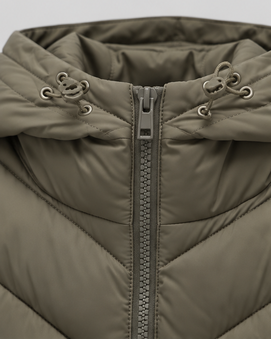 Close-up of the khaki-green hood with toggle drawcords and metal eyelets, above the chunky zip and chevron quilting. 4