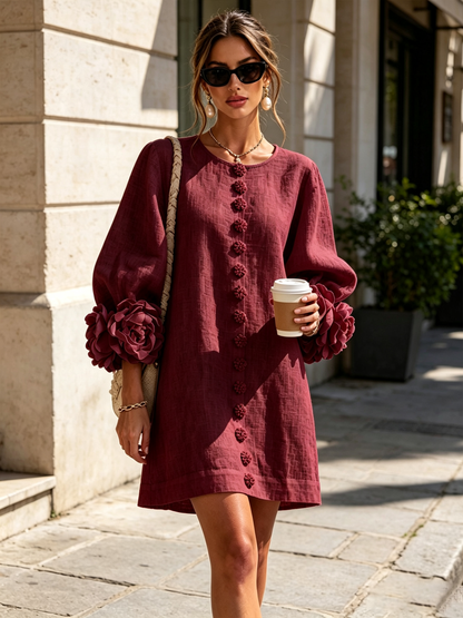 Burgundy version worn by a model on a stone pavement, with deep red rosette cuffs and flower buttons down the front. 7