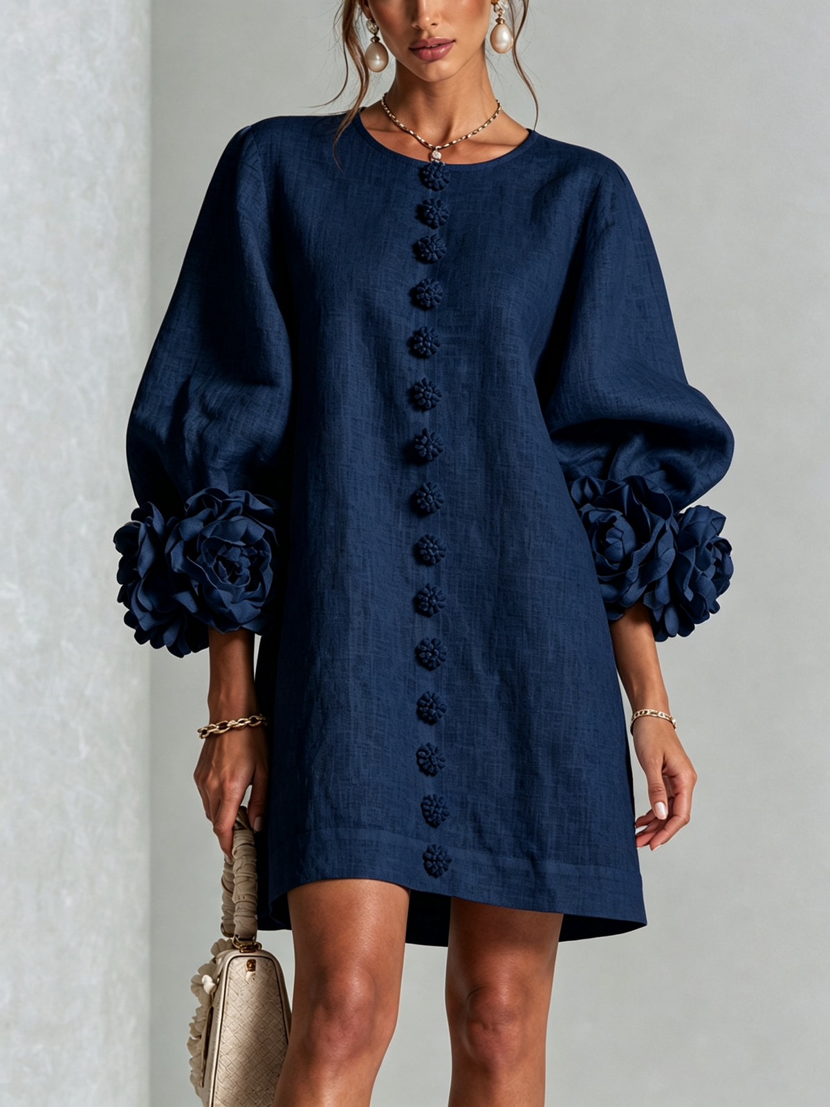Studio shot of the navy version, showing the round neckline, flower buttons down the front and rosette cuffs on balloon sleeves. 12