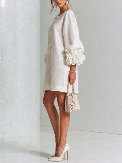 Side view of the cream dress on a model in a studio, showing the sleeve profile with a large rosette cuff and a small handbag. 13