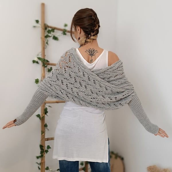 Back view of the light grey wrap with arms outstretched, showing how the knit crosses over the shoulders. 9