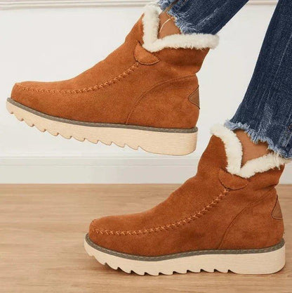 Tan suede-look ankle boots with fluffy white lining at the collar and a ridged cream sole, worn with frayed denim. 2