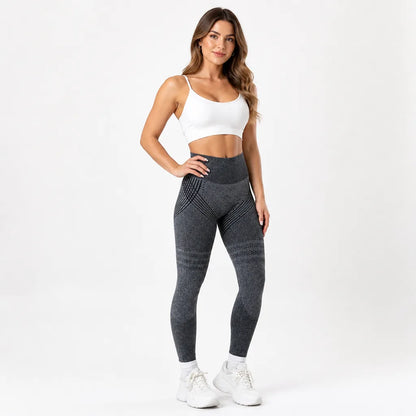 Front view of charcoal grey leggings with black line patterning at the hips and thighs, worn with a white strappy sports bra. 14