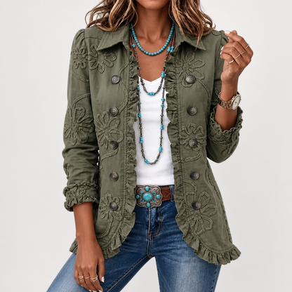 Front view of the olive green jacket worn open over a white top, showing raised floral embroidery, buttons and ruffled edges. 4