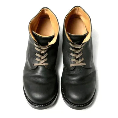 Top-down view of black leather lace-up boots, showing the grey-beige laces, rounded toe caps and tan leather interior. 4