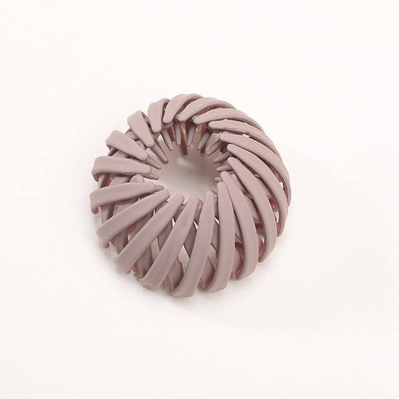 Single matte dusty mauve spiral bird's-nest clip on a plain pale background, shown from above and slightly to one side. 5