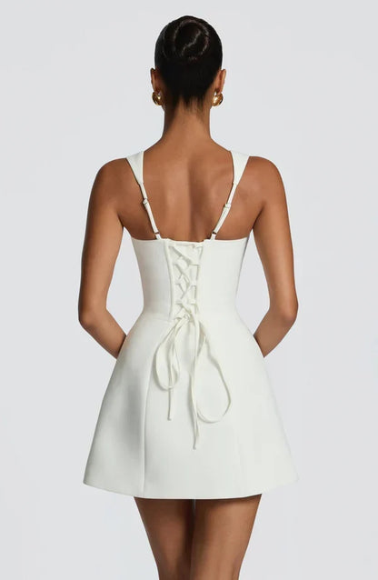 Back view of the white mini dress, showing the lace-up corset back with trailing ties and adjustable shoulder straps. 4