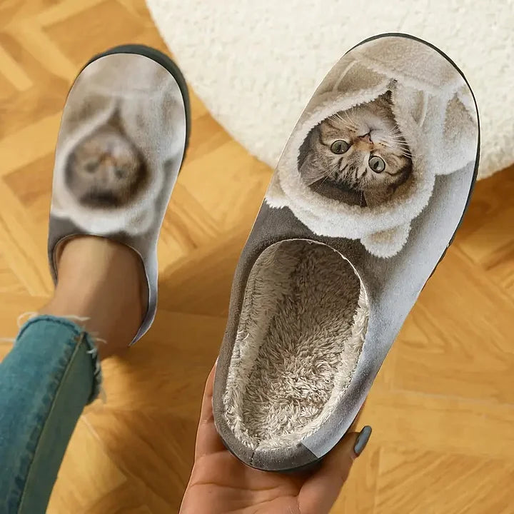 Seen from above, one slipper held in a hand shows the deep fleece lining, the other worn on a foot. 2