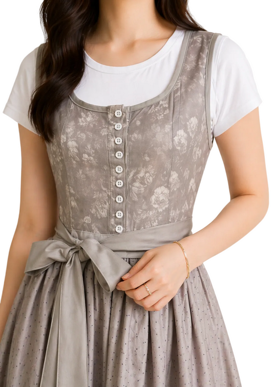 Close-up of the grey floral bodice with white buttons, scooped neckline and waist sash tied in a bow, worn over a white t-shirt. 1