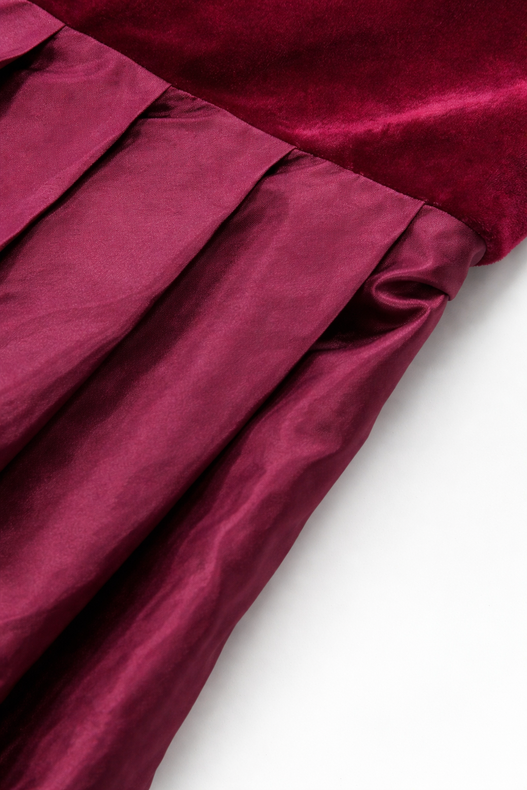 Close-up of the pleated satin-finish skirt meeting the velvet bodice at the waist seam. 2