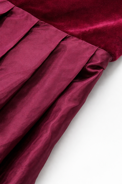 Close-up of the pleated satin-finish skirt meeting the velvet bodice at the waist seam. 2