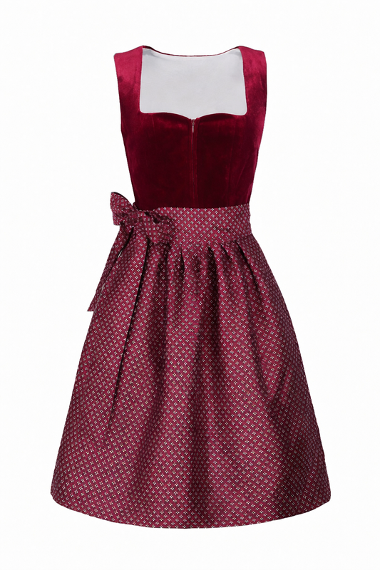 Front view of the burgundy velvet-bodice dirndl with a patterned apron tied in a bow at the left hip. 1