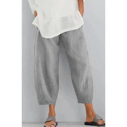 Light grey cropped wide-leg trousers with a gathered waist, worn with a loose white top and woven sandals. 4