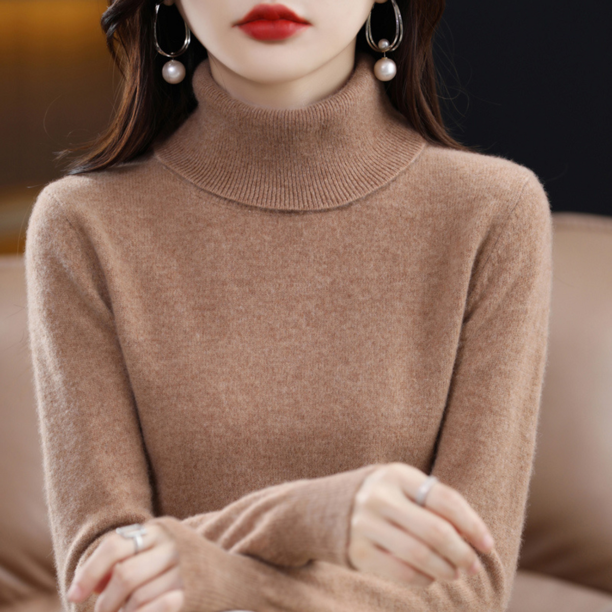 Model wearing the roll neck jumper in camel brown with a ribbed collar, hands crossed in front of her. 14