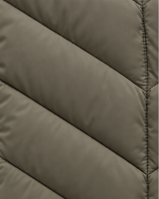 Detail of the khaki-green quilted fabric, showing the angled chevron channels and fine stitched seam down the centre. 6