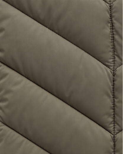 Detail of the khaki-green quilted fabric, showing the angled chevron channels and fine stitched seam down the centre. 6