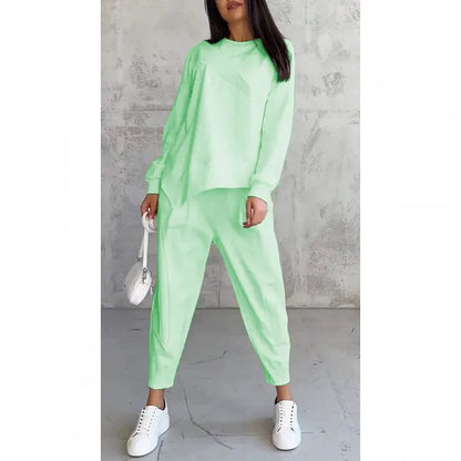 Model wearing the mint green set, front view, holding a small white bag, shown on a plain white background. 8