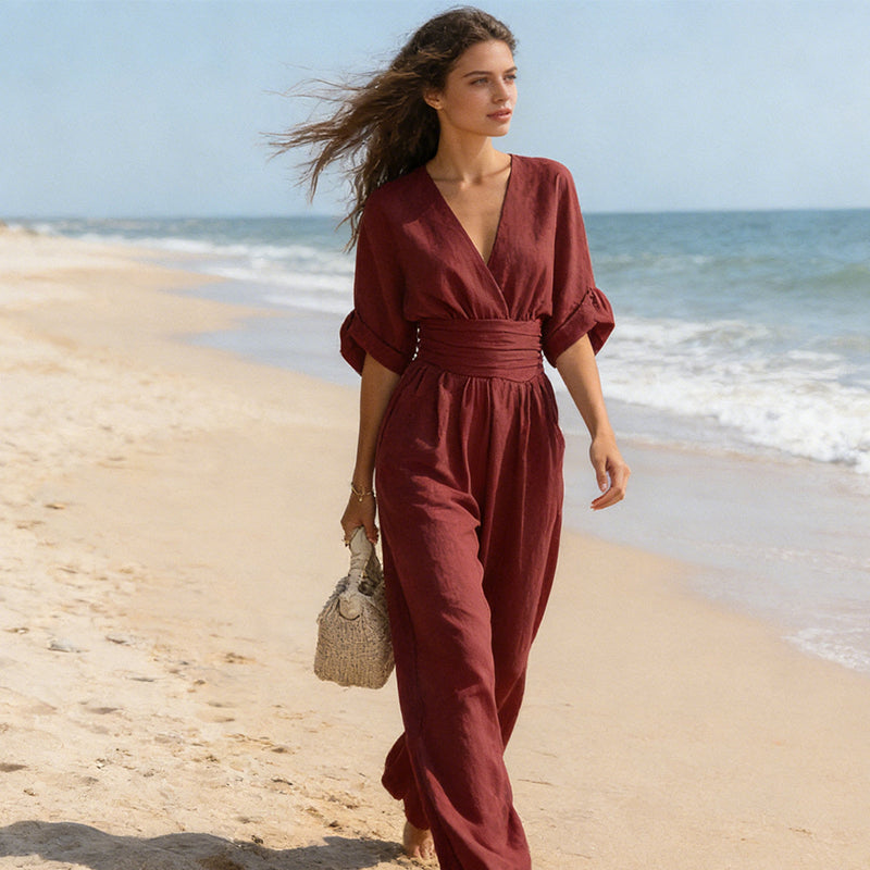 Burgundy jumpsuit worn while walking along the seashore, hair blowing in the breeze, showing the full flowing wide legs. 12