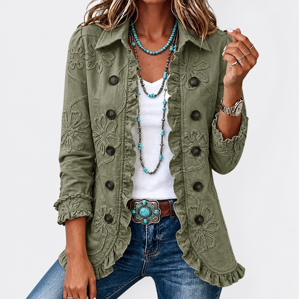 Close front view of a lighter sage green version, with tonal floral embroidery, dark buttons and ruffled front and cuffs. 6