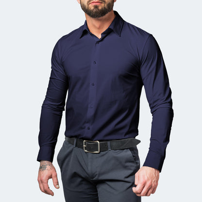Front view of a muscular bearded model wearing a navy blue shirt buttoned up with grey trousers and a black belt. 5