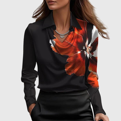 Model wears the black satin blouse with a large red and white flower printed across one shoulder and chest. 6