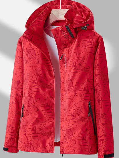 Red leaf-print version of the hooded jacket on a hanger, zipped open, with black pocket zips and hood toggles. 5