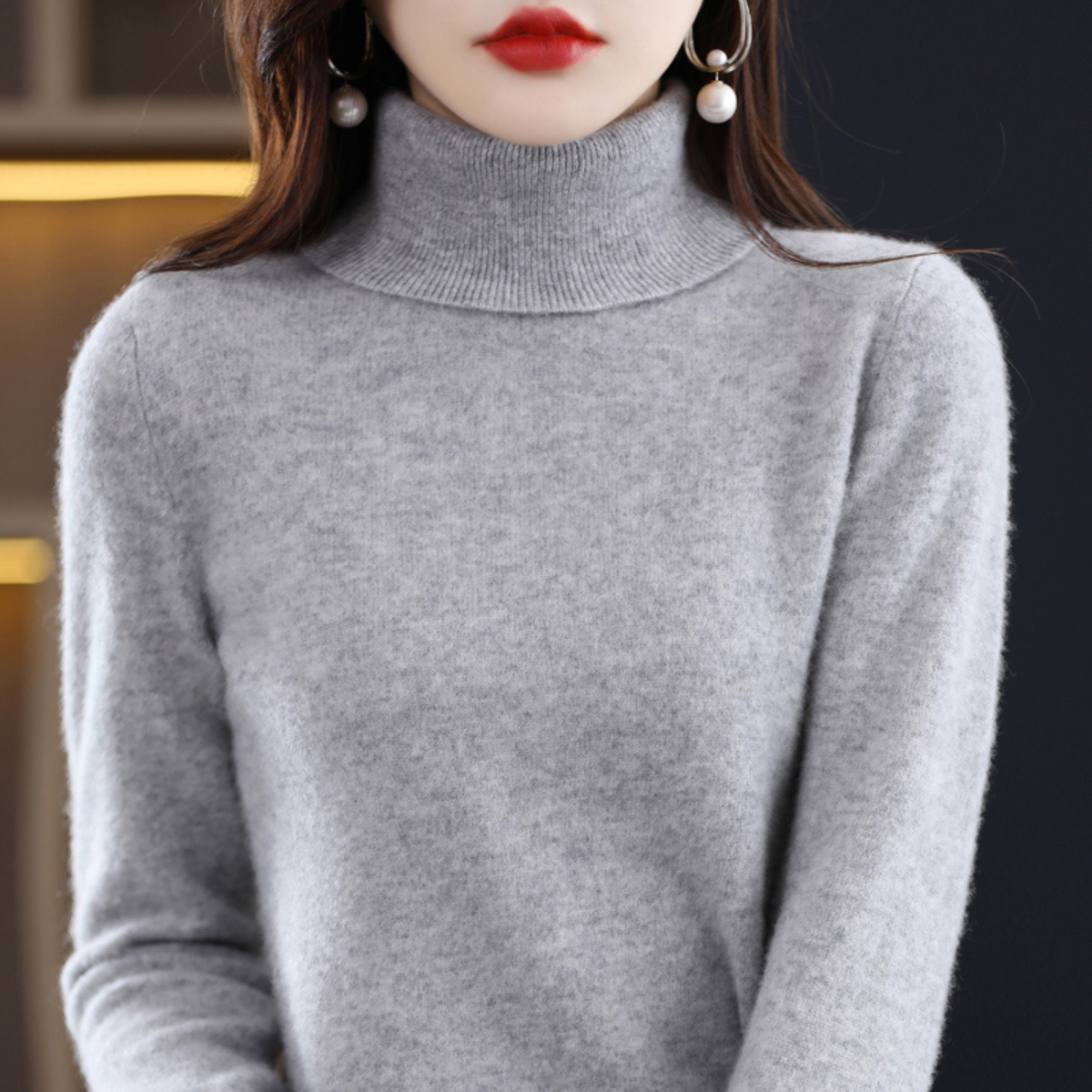Close-up of the roll neck jumper in light heathered grey, showing the ribbed collar and soft knit. 11