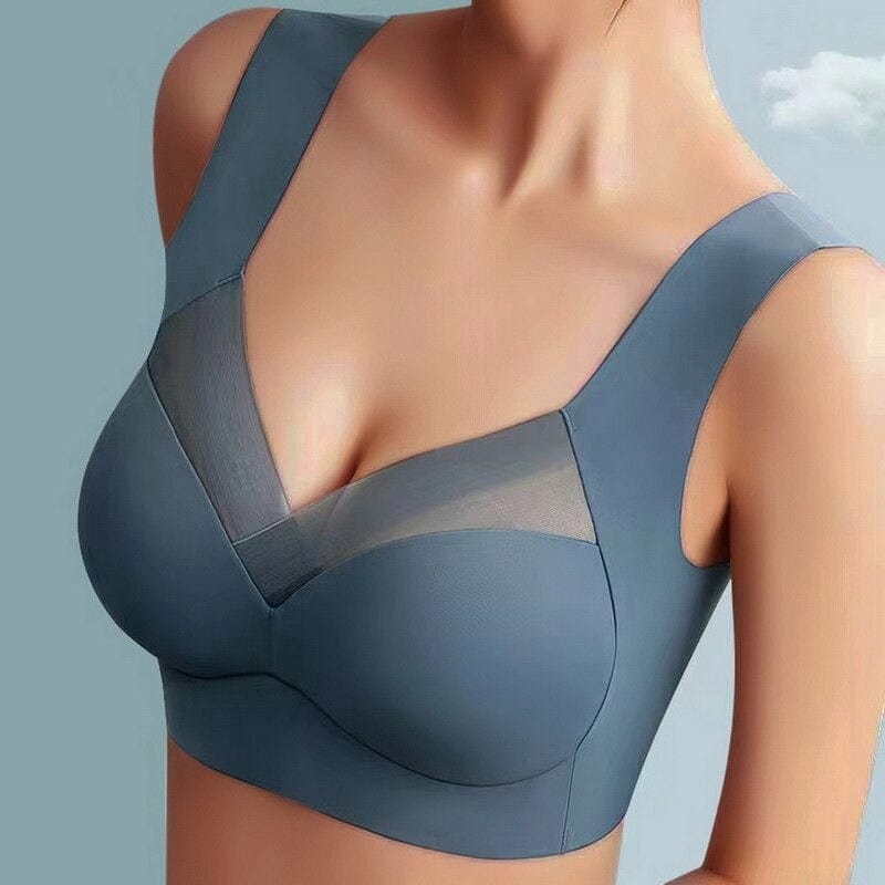 Model wearing the slate blue wide-strap bra, seen from the front, with a mesh panel across the neckline and smooth seamless cups. 1