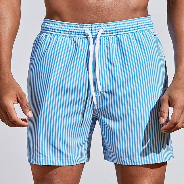 Model wearing light sky blue and white vertically striped swim shorts with a white drawstring, front view. 3