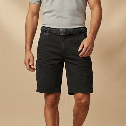 Man wearing black cargo shorts with a grey polo shirt and a woven black belt against a neutral backdrop. 10