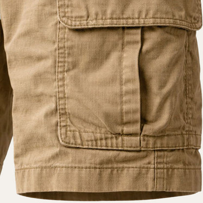 Close-up of a tan cargo pocket with its flap, pleat and stitched seams, plus the hem at the leg opening. 7