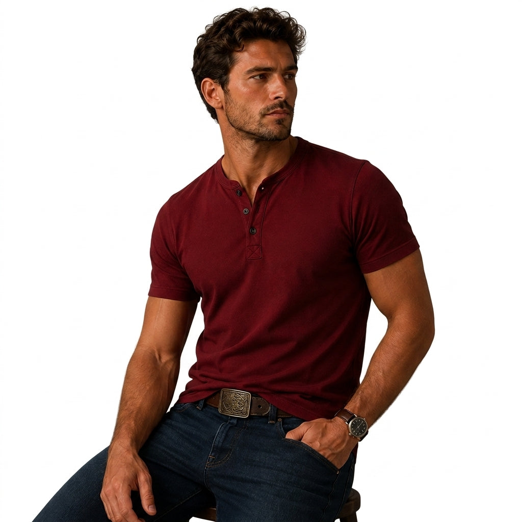 Seated man wearing the burgundy top with dark jeans, a decorative belt buckle and a watch, one hand in pocket 6