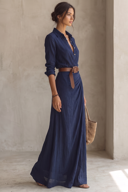 Navy blue maxi dress, full-length side view, belt buckle at the waist, bracelet, straw tote bag and flat sandals. 6