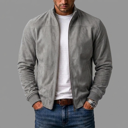 Light grey suede bomber jacket worn unzipped by a model, styled with a white t-shirt, jeans and watch. 7