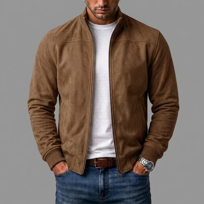 Tan brown suede bomber jacket worn open by a model with hands in jeans pockets and a white t-shirt. 5
