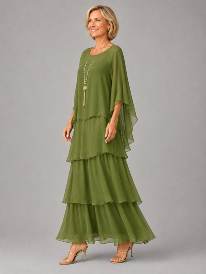 Side view of the olive green tiered chiffon maxi dress on a model, showing the draped cape sleeve and layered skirt. 13