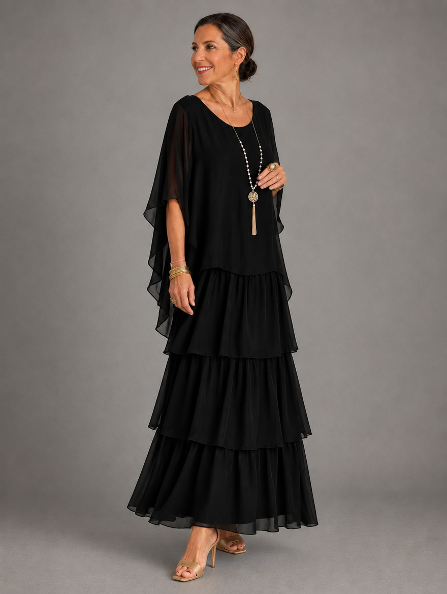 Side view of the black tiered chiffon maxi dress on a model, showing the sheer cape sleeve and three skirt tiers. 16