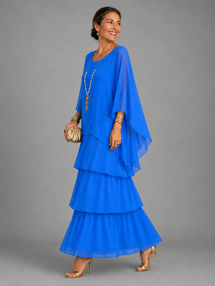 Side view of the tiered maxi dress in bright royal blue, worn with a gold clutch and heels. 25