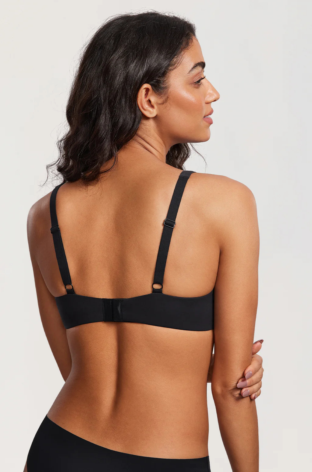 Back view of a model in the black bra, showing the adjustable straps with metal sliders and the hook-and-eye fastening. 13