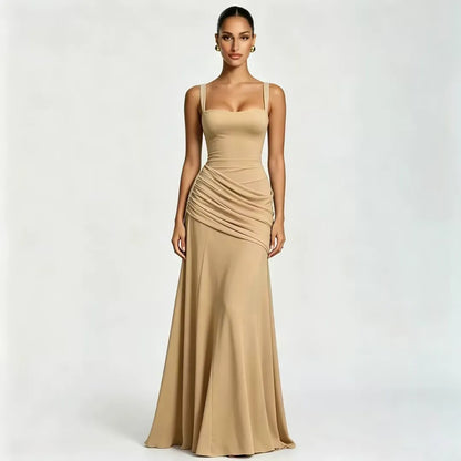 Front view of a model wearing a floor-length camel-coloured dress with a square neckline, wide straps and diagonal gathering at the waist. 21