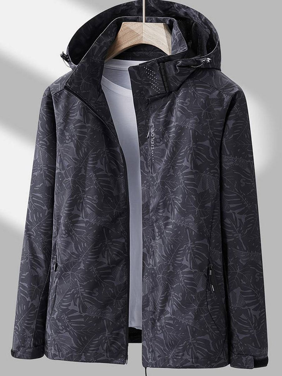 Dark charcoal leaf-print version of the hooded jacket on a hanger, open over a light grey top, with a ventilated hood lining. 6
