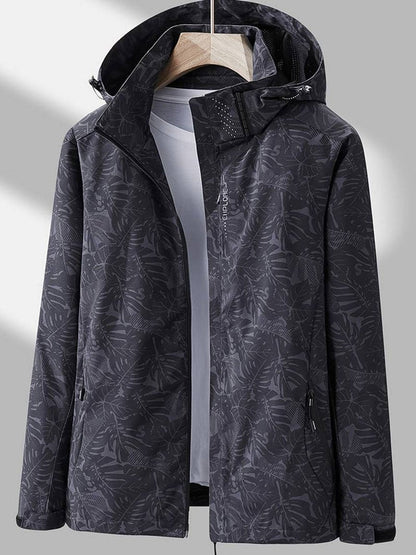 Dark charcoal leaf-print version of the hooded jacket on a hanger, open over a light grey top, with a ventilated hood lining. 6