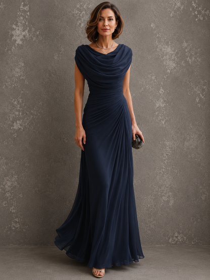 Model in the dark navy version of the draped maxi dress, facing forward with a clutch in hand and the skirt gently flared. 4