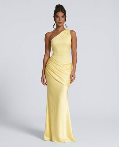 Model with hair in a bun wearing the pale yellow version, full-length front view with draped hip detail. 5