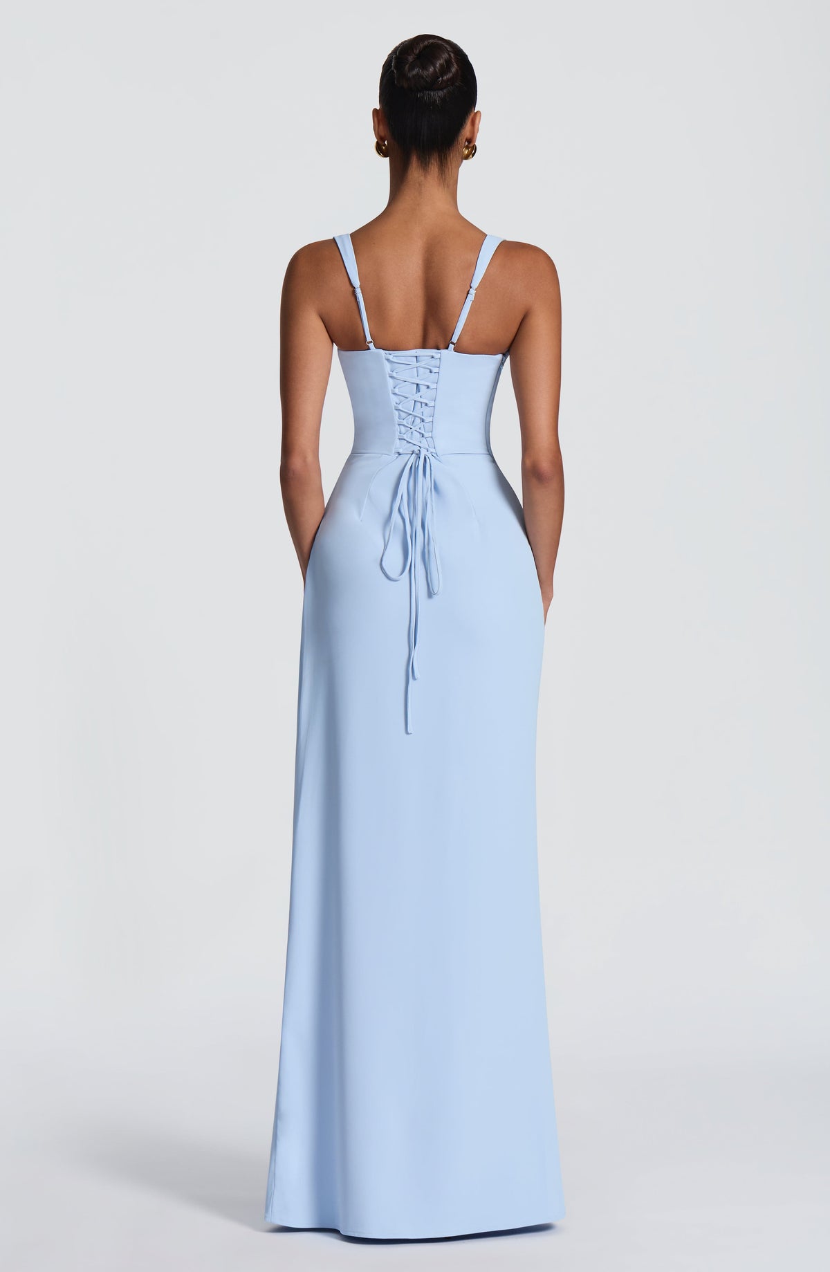 Back view of the pale blue dress with thin adjustable straps and a corset-style lace-up back with long trailing ties. 25