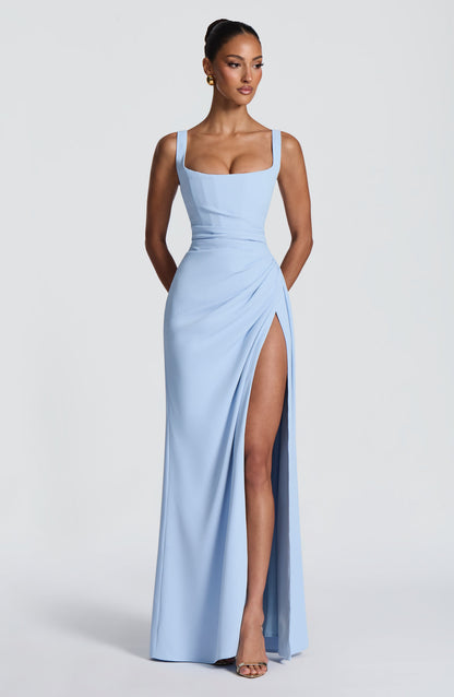 Model wearing the pale blue dress from the front, hands behind her back, showing the square neckline and high thigh slit. 24